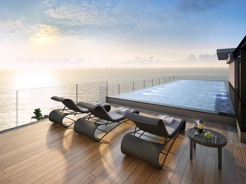 Rooftop pool and sun loungers facing the sea at Breeze Beach Side